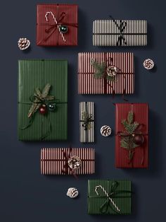 christmas presents wrapped in green and red paper with bows, pine cones and decorations on them