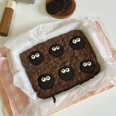 a chocolate cake with oreo eyes on it and some cookie cutters next to it