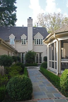 a house with a walkway leading to the front door and side windows on both sides