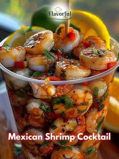 mexican shrimp cocktail in a plastic cup with lemon wedges