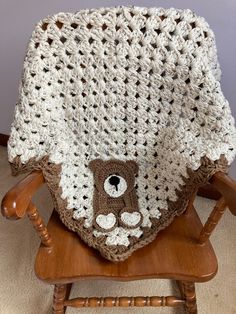 a crocheted teddy bear blanket sitting on top of a wooden chair