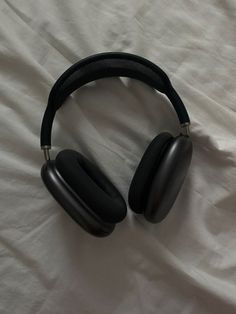 black headphones laying on top of a white sheet