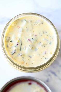 two jars filled with food sitting on top of a white counter next to each other