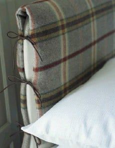 a bed with a plaid headboard and white pillows