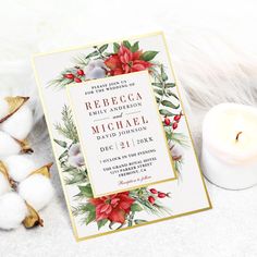 a wedding card with poinsettis and greenery on it next to a candle