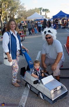 a man and woman with a child in a toy car