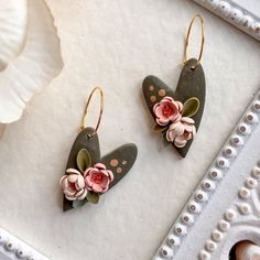 two pairs of earrings with flowers on them