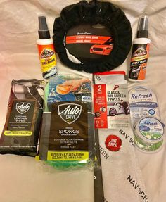 the contents of a car care kit laid out on a white sheet with black trim