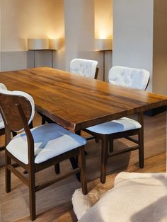 a wooden table with white chairs around it