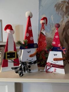 three snowmen made out of paper bags sitting on top of a table