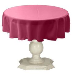 a round table with a pink cover on it's top and white pedestal base