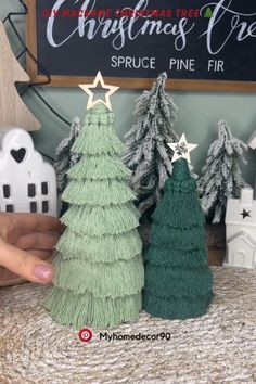 two small christmas trees sitting on top of a table