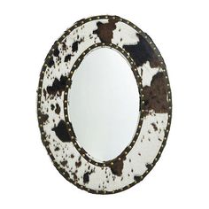 a round mirror with black and white spots on the rim, against a white background