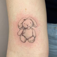 a small tattoo of a stuffed animal on the side of a woman's leg