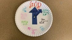 a paper plate with a blue arrow painted on it that says, god is happy birthday