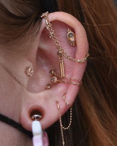 a woman with ear piercings and chains around her ears