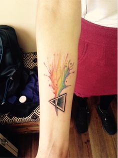 a person with a colorful tattoo on their arm and foot is holding an object in her hand