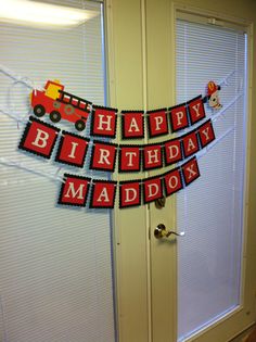 a birthday banner is hanging on the front door with cars and firetrucks