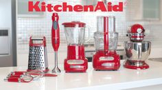 red kitchen appliances are lined up on the counter top in this kitchen setting, including blenders and mixers