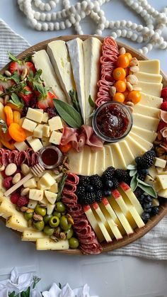 a platter filled with cheese, meats and fruit