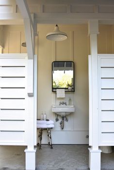 a white sink sitting under a bathroom mirror next to a wall mounted faucet