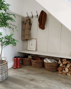 a room with some baskets and firewood stacked on the floor next to a stair case