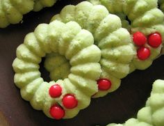 some very pretty green and red wreaths on a table with one being sliced in half