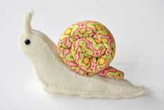 a close up of a toy snail on a white surface