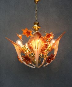 a chandelier hanging from the ceiling with flowers on it's glass petals