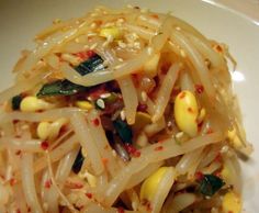 a white plate filled with noodles and vegetables on top of it's side dish