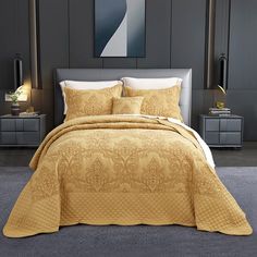 a bed with a yellow comforter and pillows