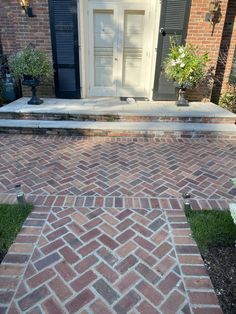 a brick walkway leading to a white door