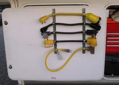 the back end of a white van with yellow hoses and tools attached to it