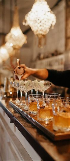 there are many glasses on the bar ready to be served