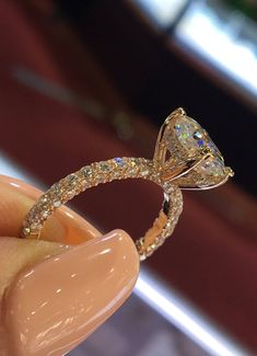 someone is holding an engagement ring with diamonds on the top and bottom half of it