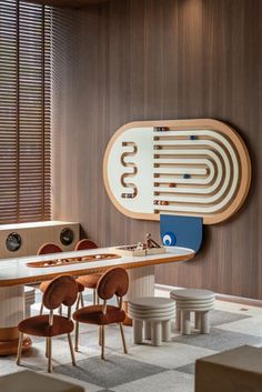 a dining room table with chairs and an oval mirror on the wall above it that reads 50