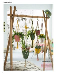 hanging planters with plants in them on a wooden stand