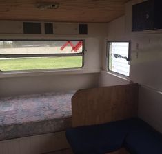 the inside of a trailer with a bed and window