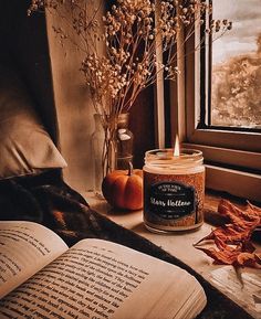 an open book sitting on top of a table next to a window