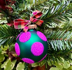 a green and purple ornament hanging from a tree