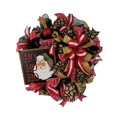 a christmas wreath with a santa clause on it and red, gold and white ribbons