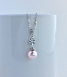 Classic cubic zirconia and pearl bridal drop earrings in rhodium plated brass setting. Earrings feature clear cubic zirconia teardrop ear post with cubic zirconia connector and 10mm Swarovski pink pearl dangle drops. Total length of the earring is 3.5 cms. For matching necklace click: https://www.etsy.com/listing/518298752/pink-pearl-bridal-necklace-blush-pink?ref=shop_home_active_2 For complete set click: https://www.etsy.com/listing/518297586/pink-pearl-bridal-earrings-blush-pink?ref=listing-s Pink Pearl Pendant Jewelry For Wedding, Pink Pearl Charm Earrings For Wedding, Pink Pearl Charm Wedding Earrings, Classic Pink Pearl Earrings For Wedding, Classic Pink Pearl Wedding Earrings, Bridal Jewelry Pearl Sets, Pink Jewelry Set, Swarovski Pearl Necklace, Pink Pearl Earrings