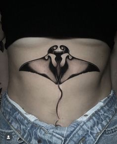 a woman's stomach with a black and white tattoo design on the side of her belly