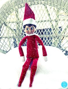 an elf doll is sitting in the snow