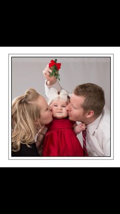 a family kissing each other while holding their baby in front of the photographer's face