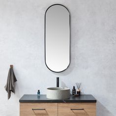 a bathroom vanity with a round mirror above it