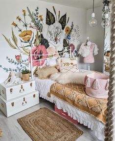 a bedroom decorated in pink and gold with flowers on the wall