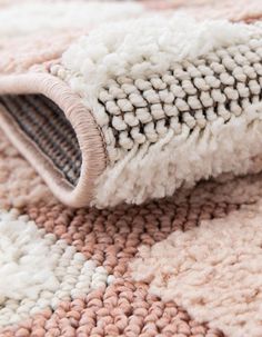 a close up view of a rug on the floor with white and pink carpeting