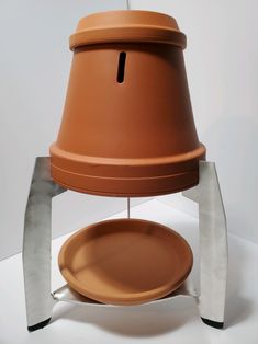 a large brown pot sitting on top of a metal stand