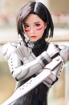 a woman dressed in black and white holding a sci - fi type arm with red eyeliners